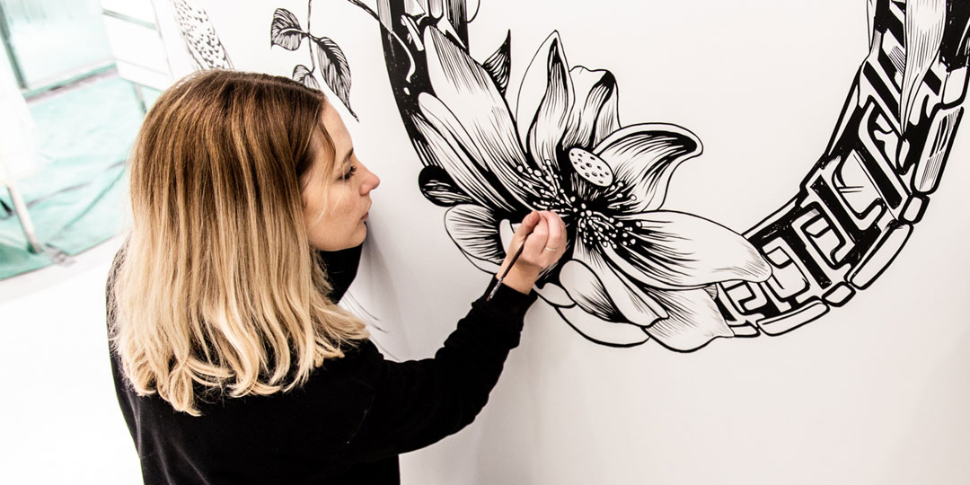一个女人在墙上画一朵花